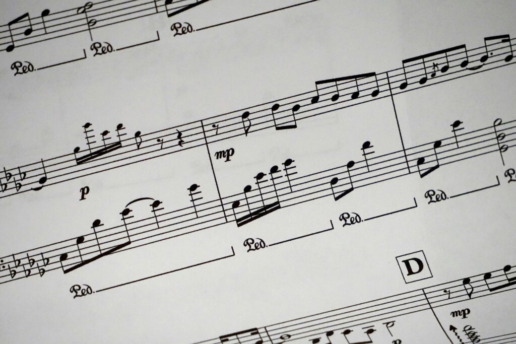 Close-up of a detailed musical sheet showcasing notes and symbols in black and white.